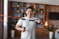 Home fitness. Happy asian man exercising using resistance rubber band, training in living room at home Royalty Free Stock Photo