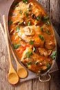 Home French chicken chasseur with mushrooms and tomatoes close-up. Vertical top view