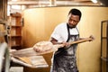 The home of fresh baking. a male baker removing freshly baked bread from the oven.