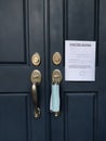 Home front door with eviction notice and facemask for renter in default during coronavirus pandemic