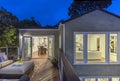 Home with furniture patio / wooden deck at twilight.