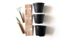 Home garden suplies, small shovel and rake, plastic pots for seedlings, paper bag with seeds of thyme,rosmery ,parsley