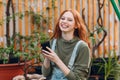 Home gardening concept. Young pretty woman smiling laughing with flower pot in hands. Spring home garden plant.