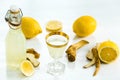 Home ginger tincture in a glass and fresh lemons on the white wooden background