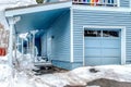 Home with grayish blue wall attached garage and stairs leading to the entrance