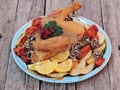 Home-grown smoked or fried chicken with red tomatoes and spices on a natural wooden background.Natural food.Side view Royalty Free Stock Photo