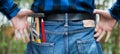 Home handyman: Rear view of a young man with hammer, pencil and gripper in his pocket