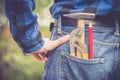 Home handyman: Rear view of a young man with hammer, pencil and gripper in his pocket