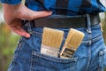 Home handyman: Rear view of a young man with paint brushes in his pocket