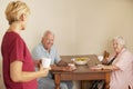 Home Help Sharing Cup Of Tea With Senior Couple In Kitchen Royalty Free Stock Photo