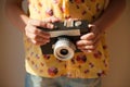 Home hobby leisure concept photograph of little kid in yellow shirt holding vintage film camera