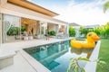 Home or house Exterior design showing tropical pool villa with greenery garden, sun bed, umbrella, pool towels and colorful Royalty Free Stock Photo