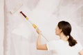 Home improvement. Beautiful woman painting wall with paint roller. Royalty Free Stock Photo