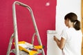 Home improvement. Beautiful woman painting wall with paint roller. Royalty Free Stock Photo