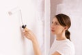 Home improvement. Beautiful woman painting wall with paint roller. Royalty Free Stock Photo