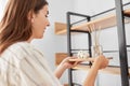 Woman placing aroma reed diffuser to shelf home