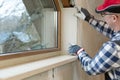 Home improvement handyman installing window in new build attic by using leveler and laser leveler Royalty Free Stock Photo