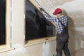 Home improvement handyman installing window in new build attic by using leveler and laser leveler Royalty Free Stock Photo