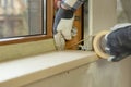 Home improvement handyman installing window in new build attic by using leveler and laser leveler Royalty Free Stock Photo