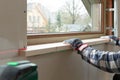 Home improvement handyman installing window sill in new build attic by using leveler and laser leveler Royalty Free Stock Photo