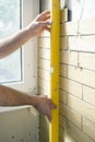 Home improvement - handyman measures straightness of the wall. Royalty Free Stock Photo
