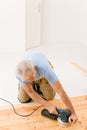 Home improvement - handyman sanding wooden floor Royalty Free Stock Photo