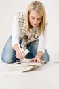 Home improvement - handywoman measuring tile Royalty Free Stock Photo