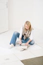 Home improvement - handywoman measuring tile Royalty Free Stock Photo