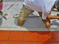 Home improvement, renovation - construction worker tiler is tiling, ceramic tile floor adhesive Royalty Free Stock Photo