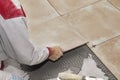 Home improvement, renovation - handyman laying tile with level Royalty Free Stock Photo