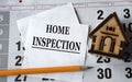 HOME INSPECTION - words on white paper on the background of a house, pencil and calendar Royalty Free Stock Photo