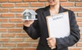 Home insurance concept and real estate. Businesswoman holding a house model working in investment about renting a house, buying a Royalty Free Stock Photo