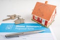 Home insurance proposal form with miniature red house and pen laying on white office desk. Royalty Free Stock Photo