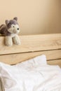 Home interior, bedroom, brown wooden bed, two white pillows, a dog doll