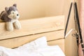 Home interior, bedroom, brown wooden bed, two white pillows, a dog doll