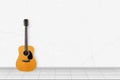 Home interior - Classic vintage acoustic guitar in front of white wall Royalty Free Stock Photo