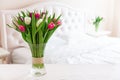 Home interior with pink tulips in a vase on a light bedroom background Royalty Free Stock Photo