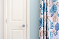 Home interior showing colonial closet door with blue curtain decor and light blue painted wall