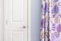 Home interior showing colonial closet door with purple curtain decor and light blue painted wall