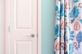 Home interior showing colonial closet door with turquoise curtain decor and light blue painted wall