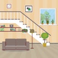 Home interior.Sofa located under the stairs,vase with a plant