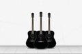Home interior - Three black guitar in front of white wall