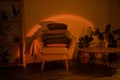 Home interiour, cozy chair with pillows at sunset