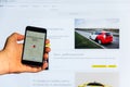 The home Internet page of the mobile application Yandex taxi on the screen the smartphone in male hand on a against the backgroun