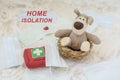 Home isolation, text of motivational words, on background of toy puppy, medical masks and first aid kit , infection and
