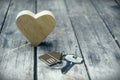 Home key with house keychain and wooden heart mock up on vintage wood background, home sweet home concept Royalty Free Stock Photo