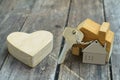 Home key with house keychain and wooden heart mock up on vintage wood background, home sweet home concept Royalty Free Stock Photo