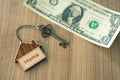 Home key with house keyring on dollar bill stack Royalty Free Stock Photo