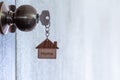 Home key with house keyring in keyhole on wooden door Royalty Free Stock Photo