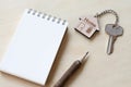 Home key with house keyring, pencil, note book on wooden table Royalty Free Stock Photo